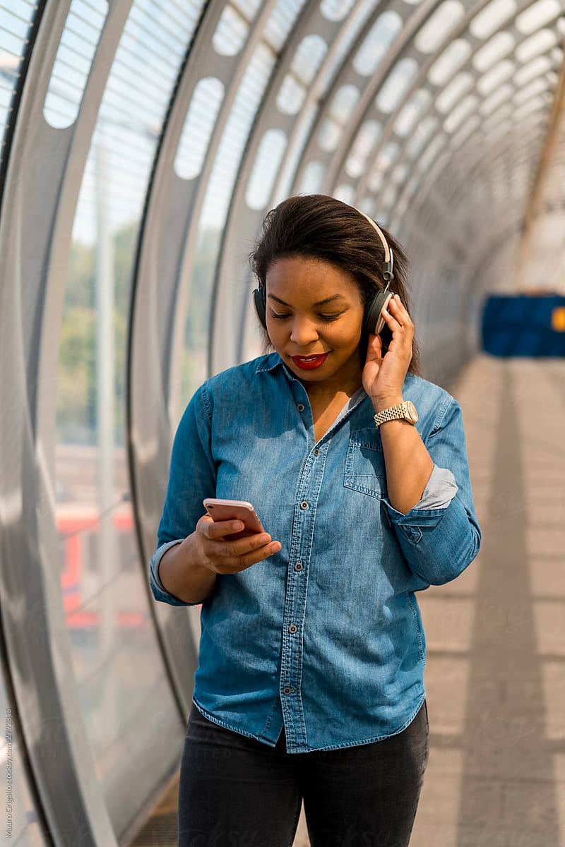 Black woman listening to music from mobile phone