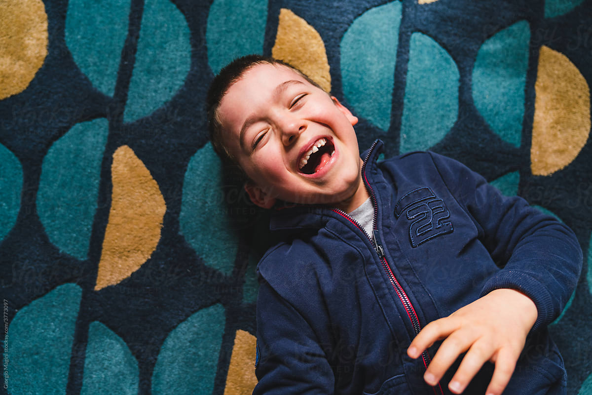 Happy Kid Laughing on a Carpet