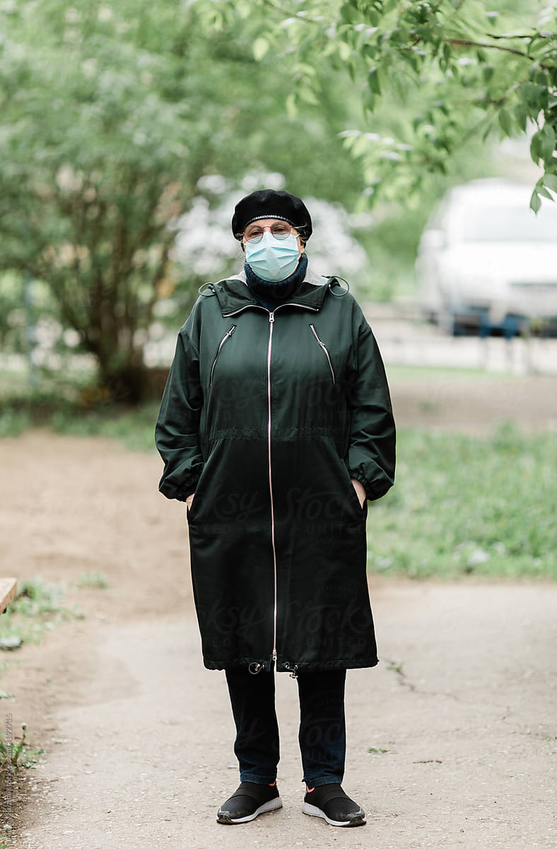 Senior woman wearing disposable mask outdoors