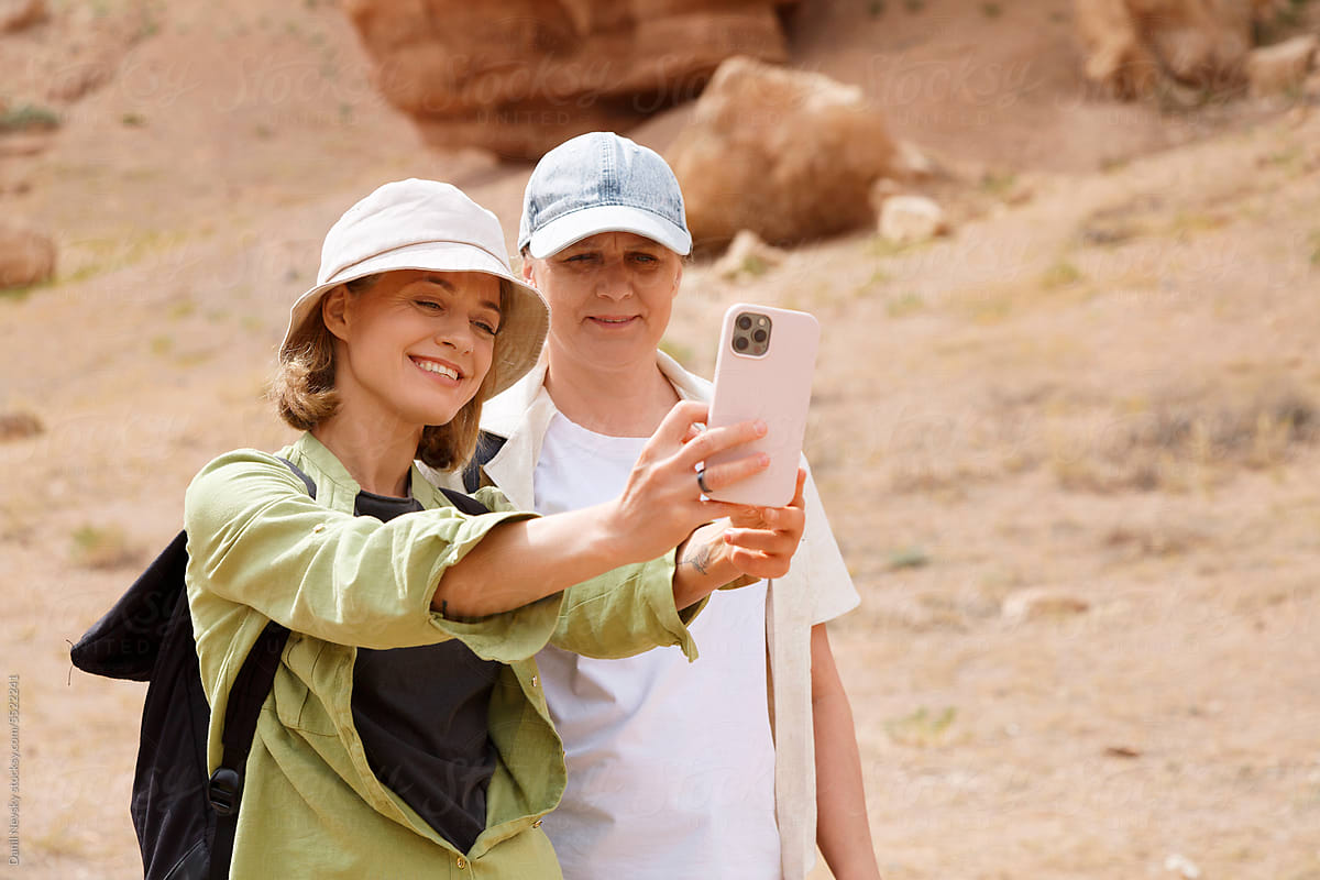 Happy travelling women taking selfie in canyon