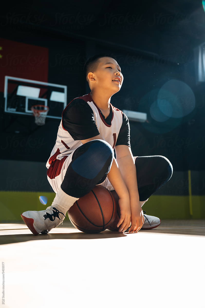 Boy practicing basketball in gym