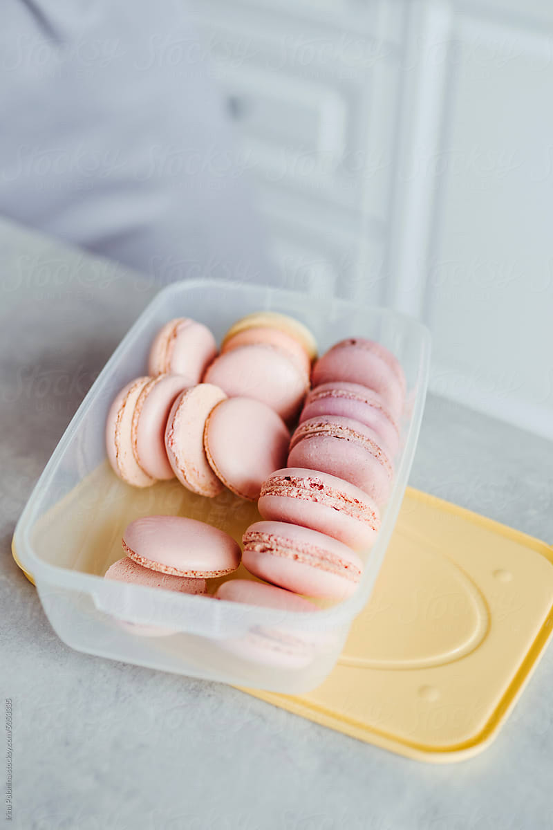 Pink color macarons in container.