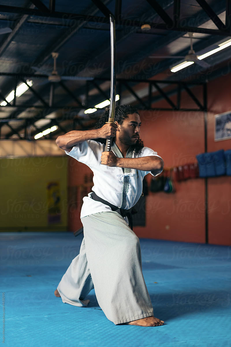 Man training martial arts with katana