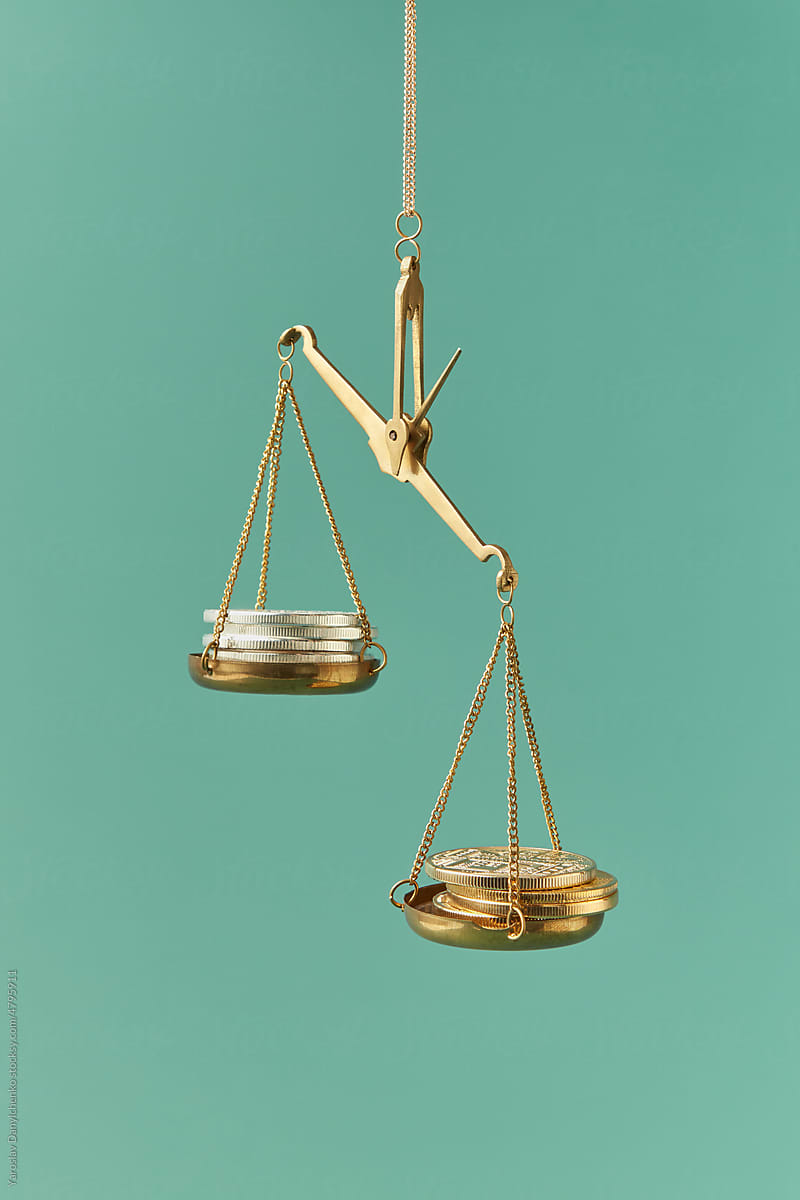 Balance scales with silver and golden coins.