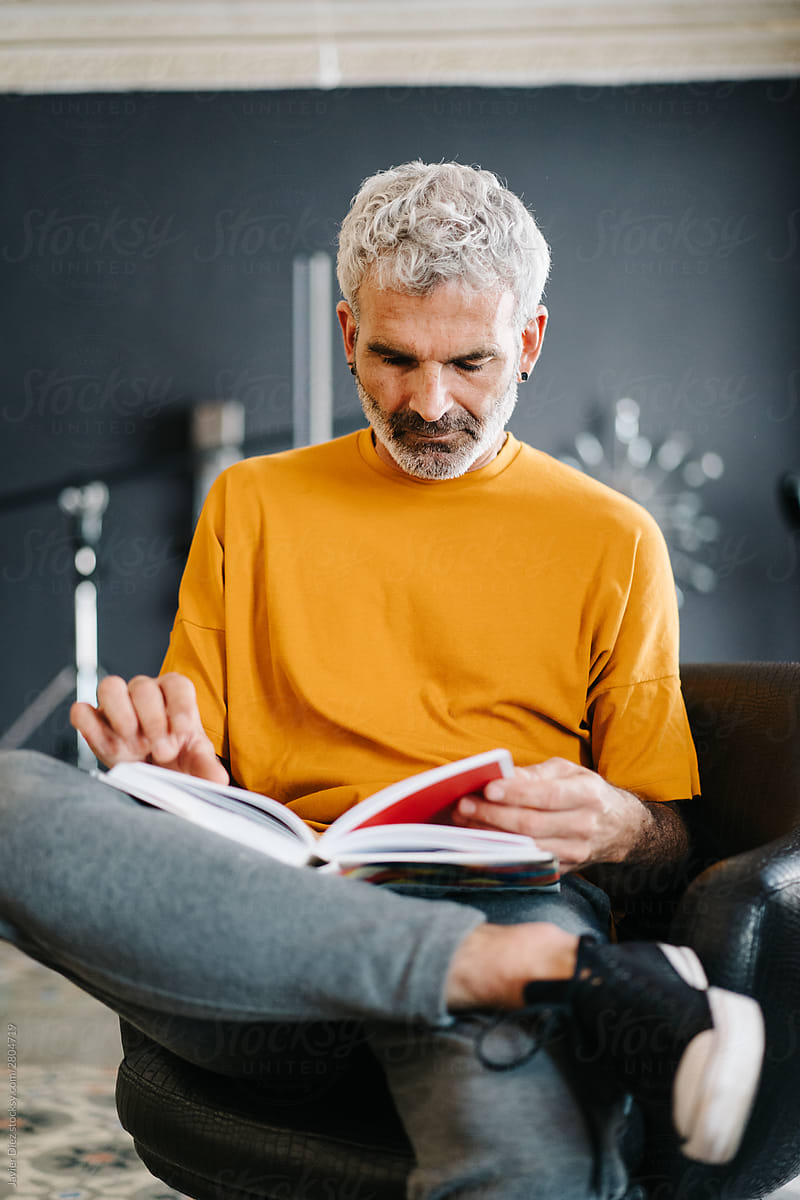 Stylish senior man reading book