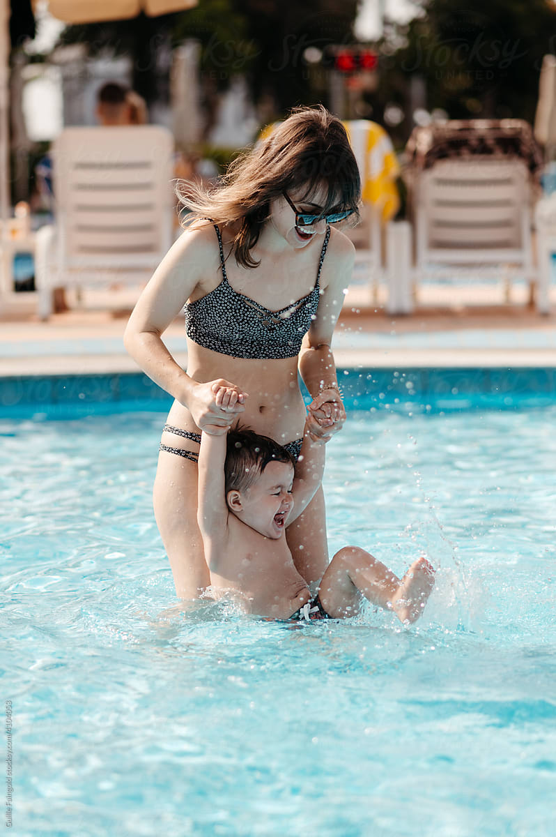 Mother having fun with son in pool.