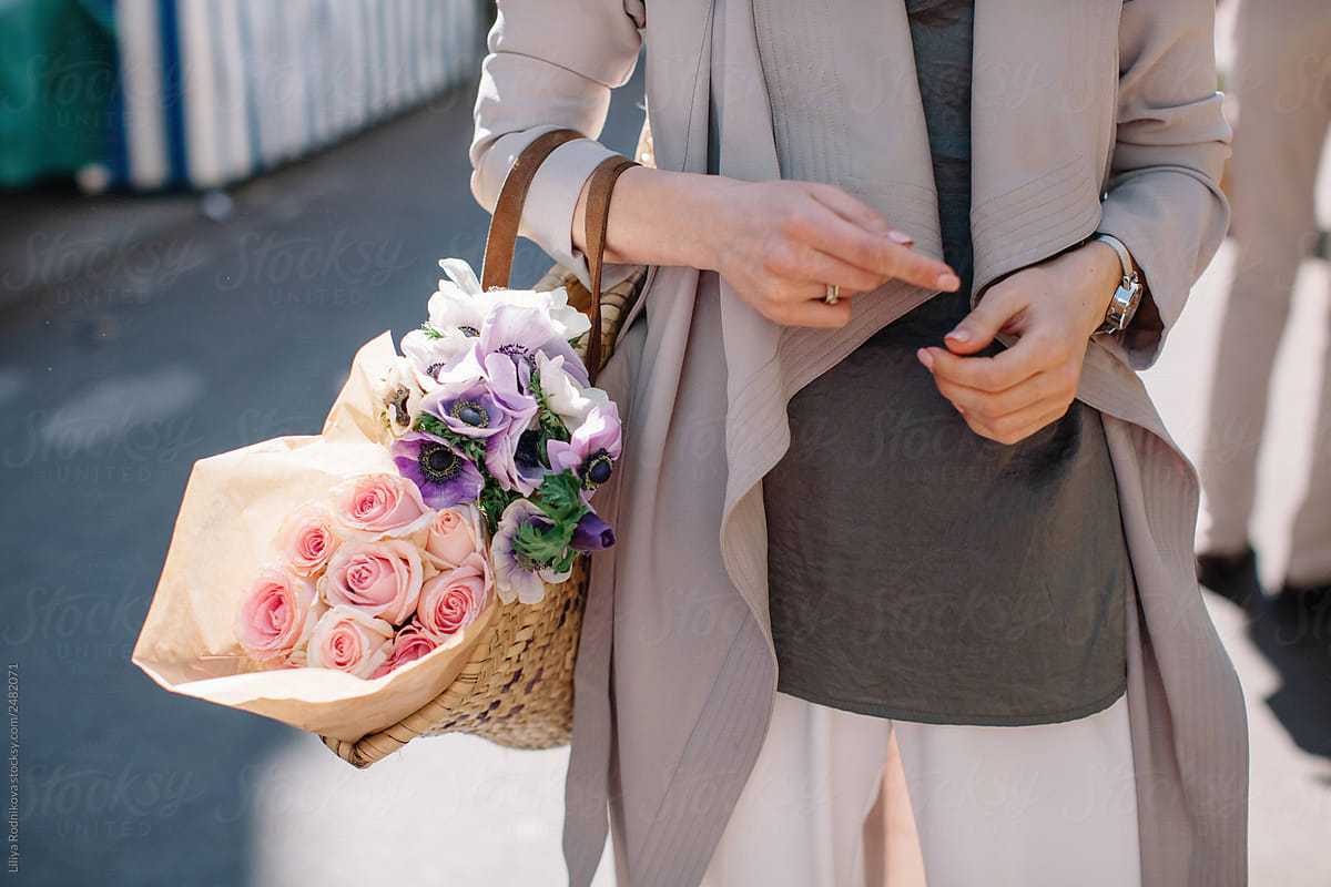 Unrecognizable woman holding basket with flowers
