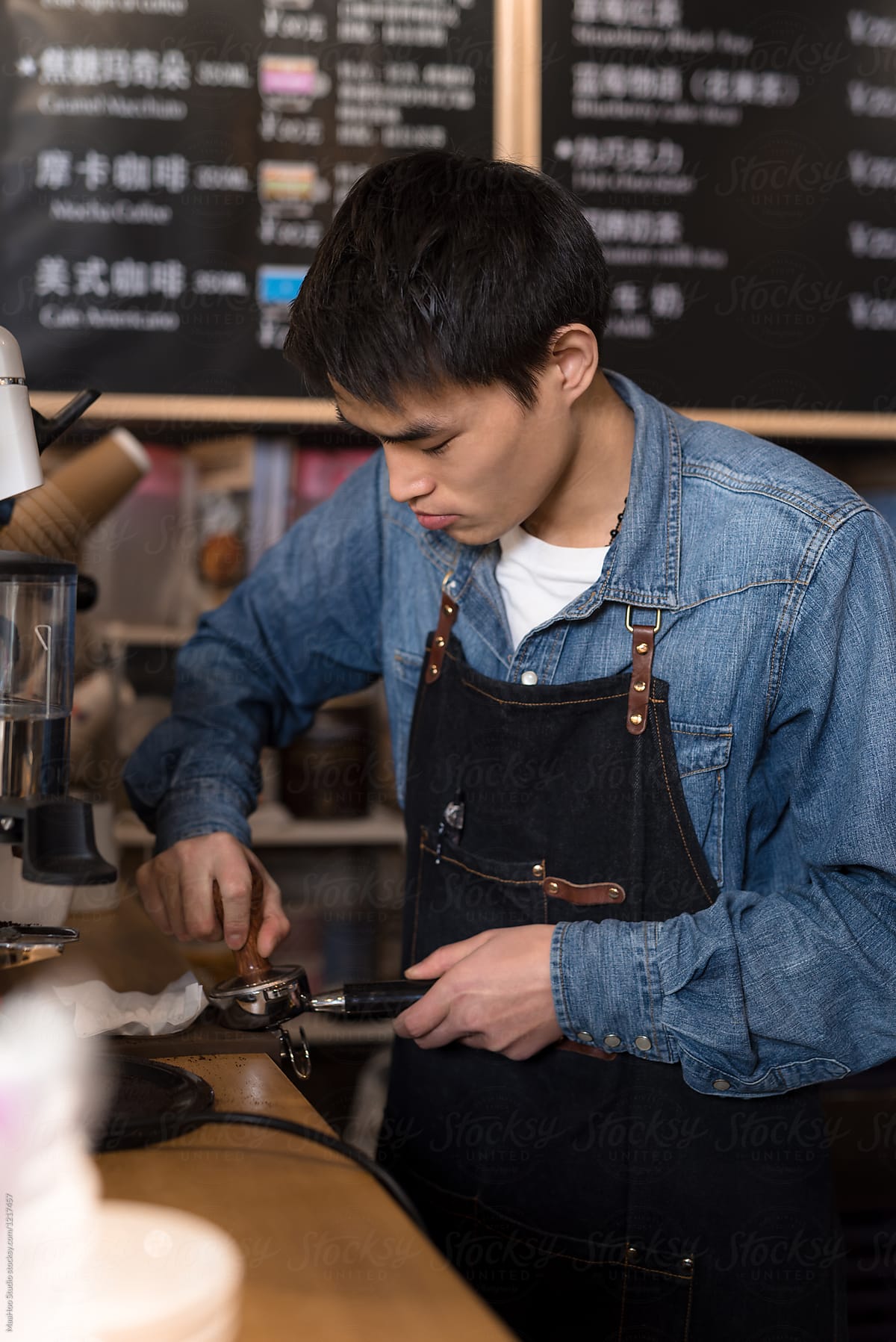 Young coffee shop owner making coffee