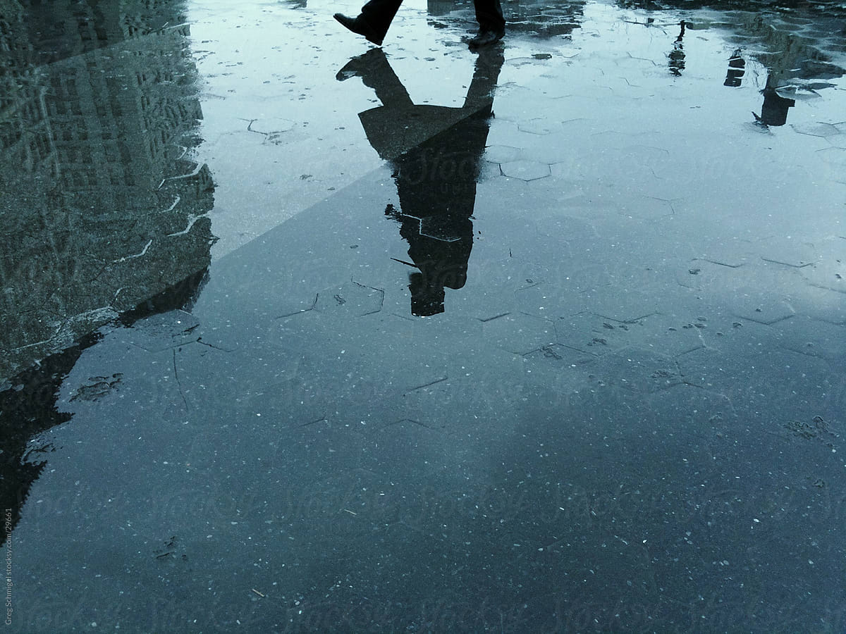 Man walking in rain reflection