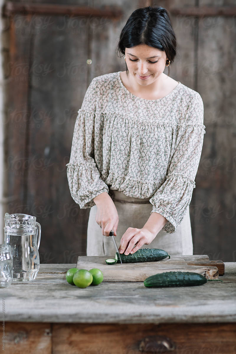 Woman cutting cucumber for water