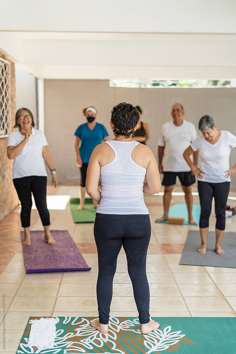 Yoga instructor with older adults standing