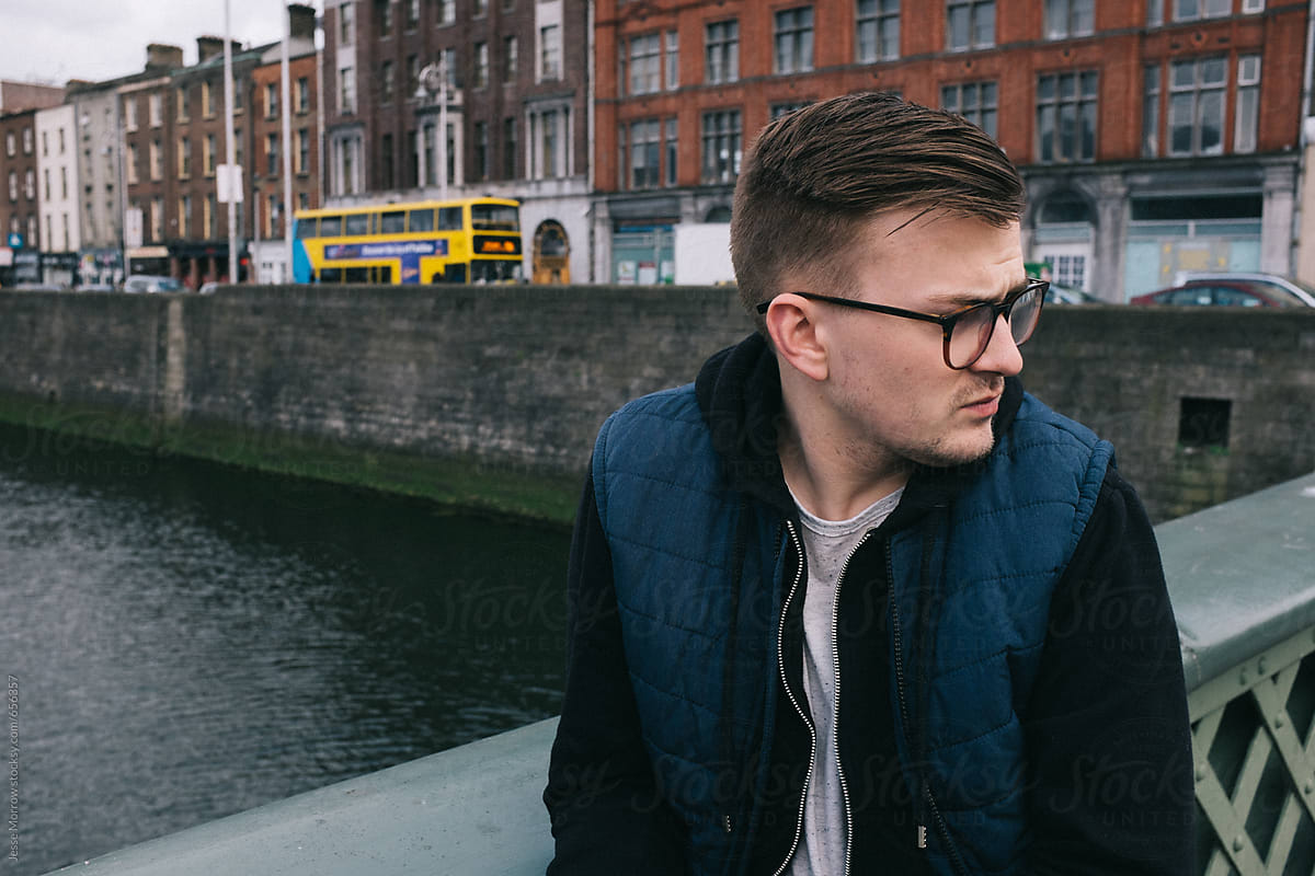 young man looking away from camera on bridge in dublin city center