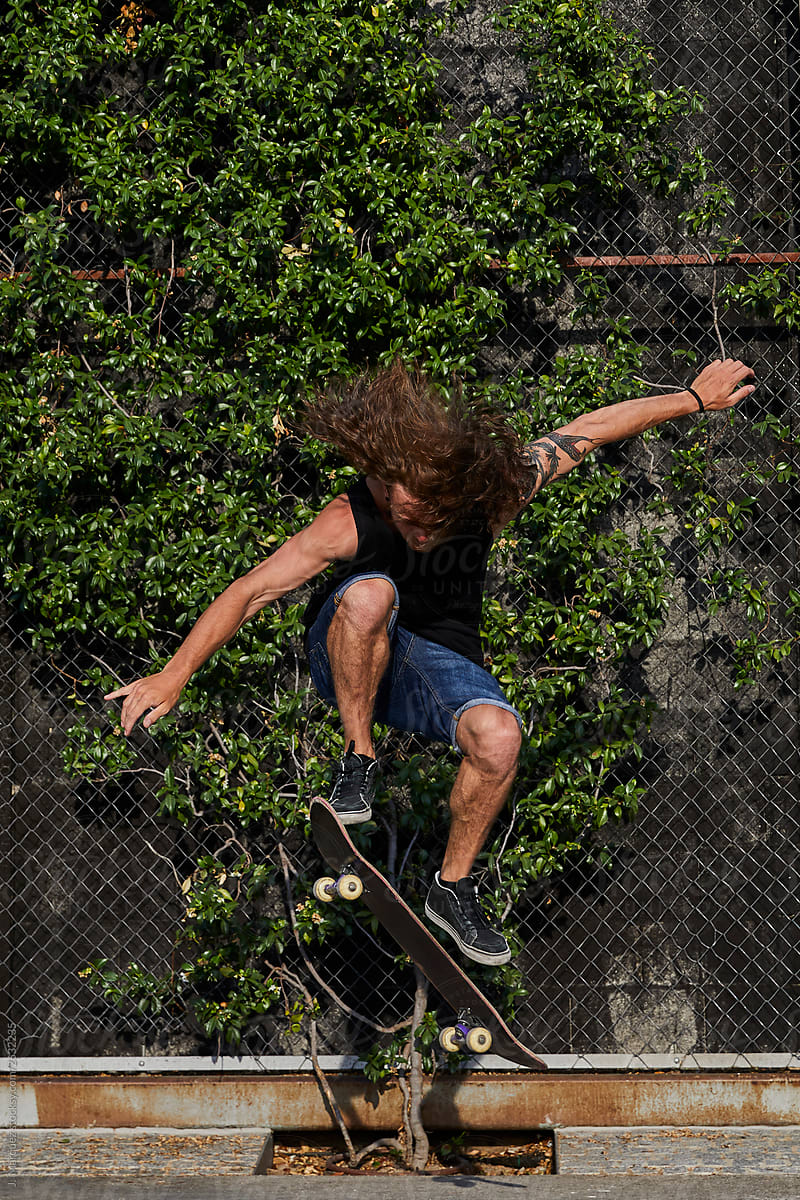 Skater doing trick near fence on street