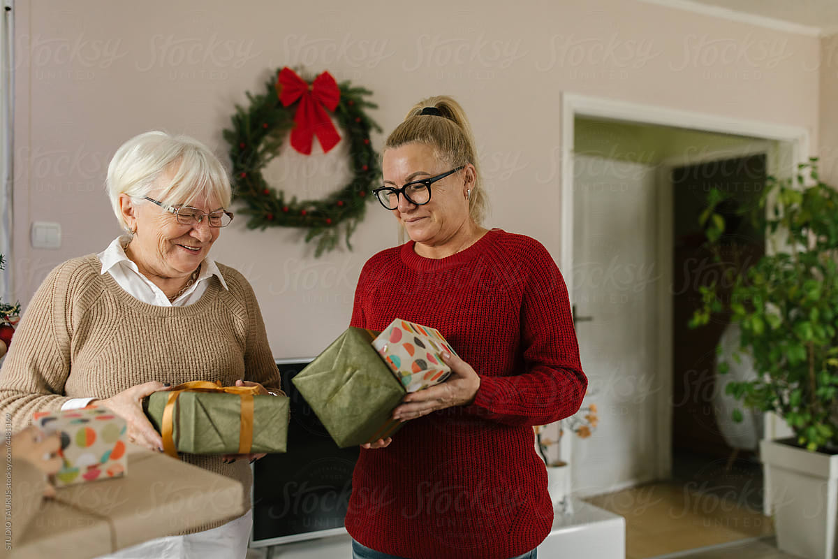 Mother and daughter exchanging Christmas gifts at home
