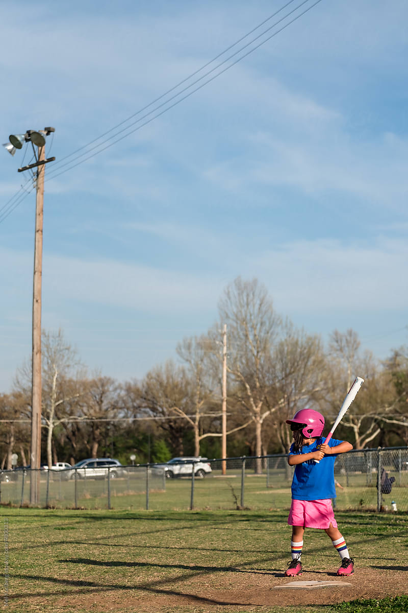 Girl playing baseball wearing colorful uniform 4
