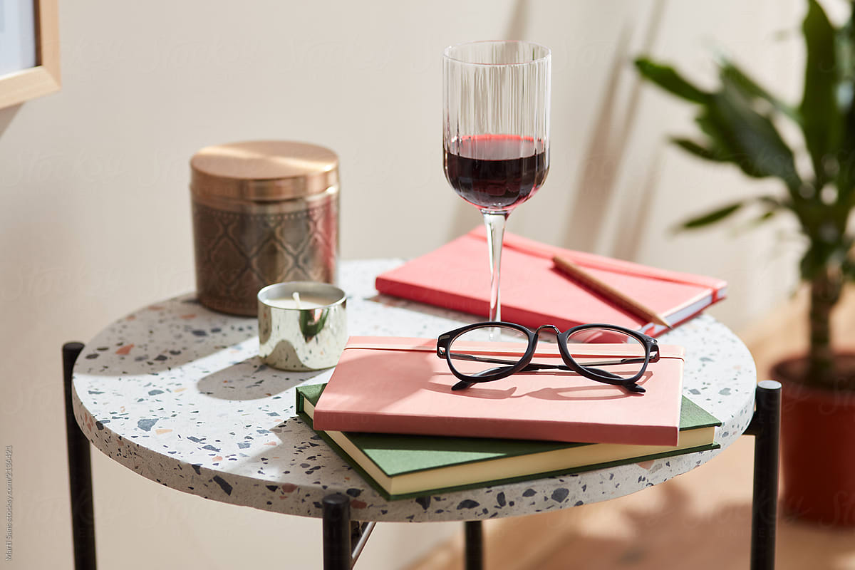 Still life of glass of wine, glasses and notebooks.