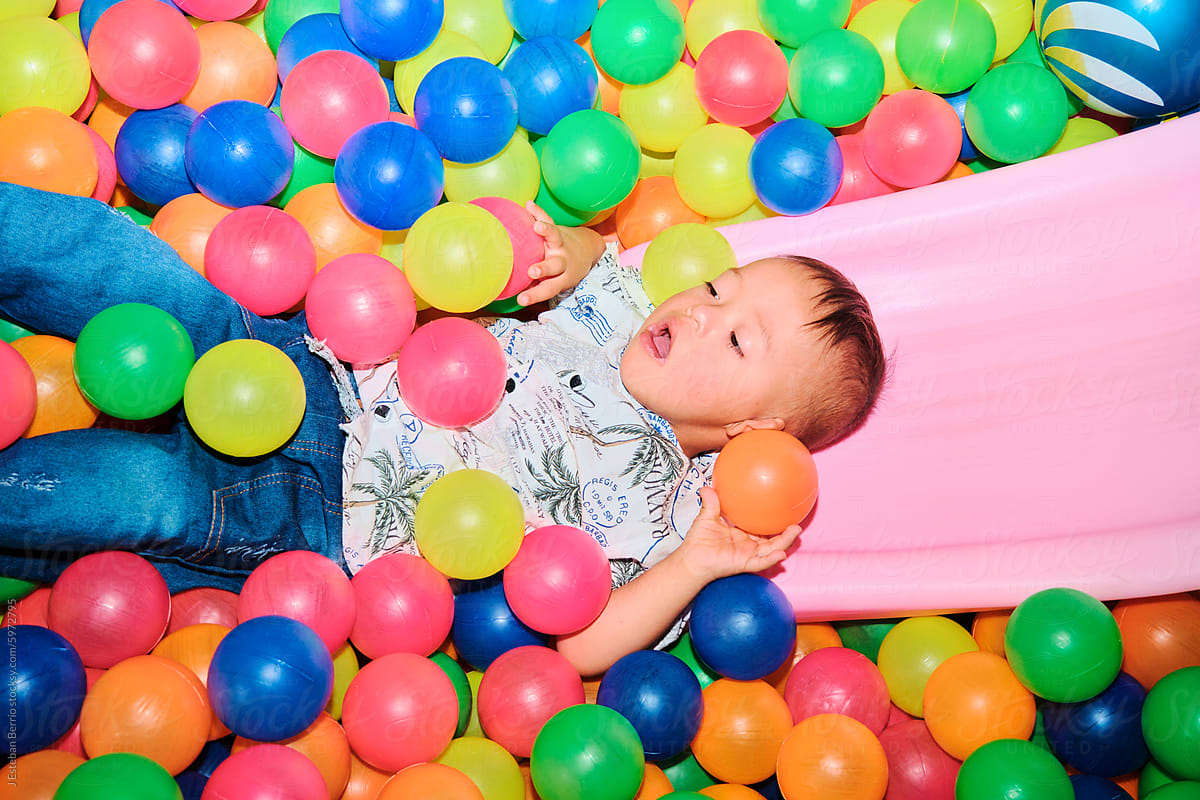 Latino child playing in a ball pool