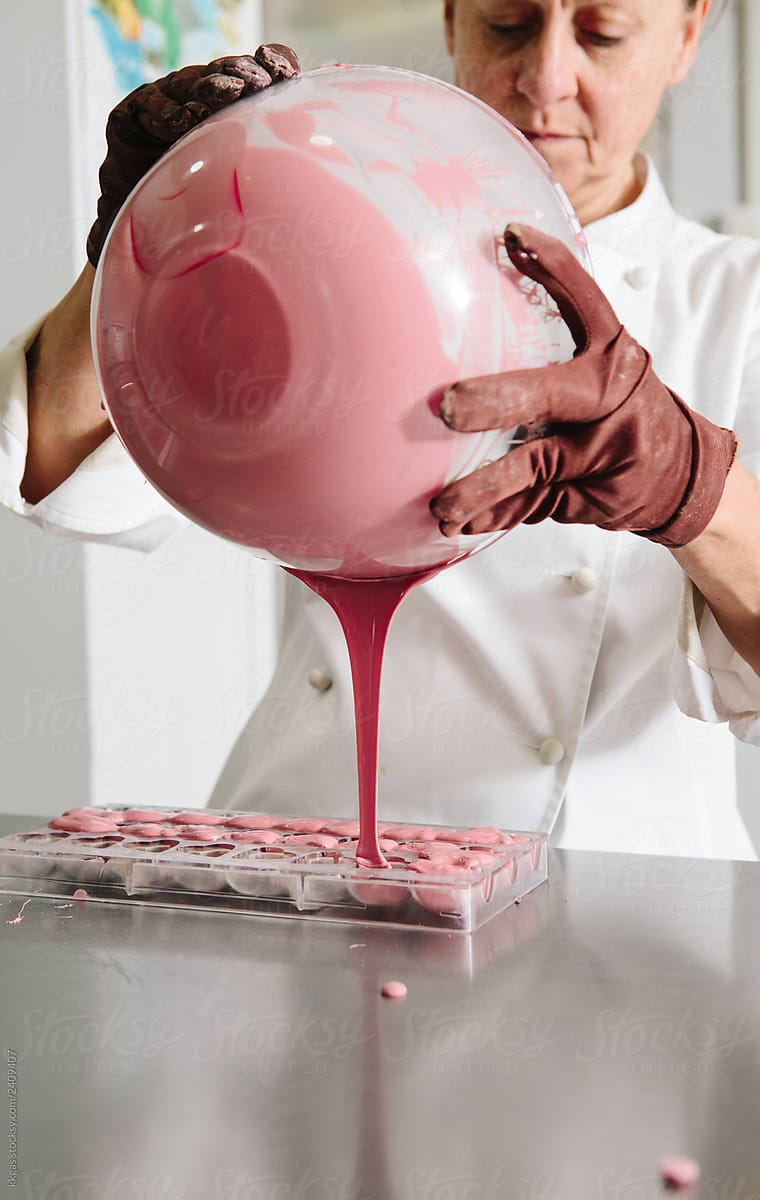 Pink chocolate being poured into a mould.