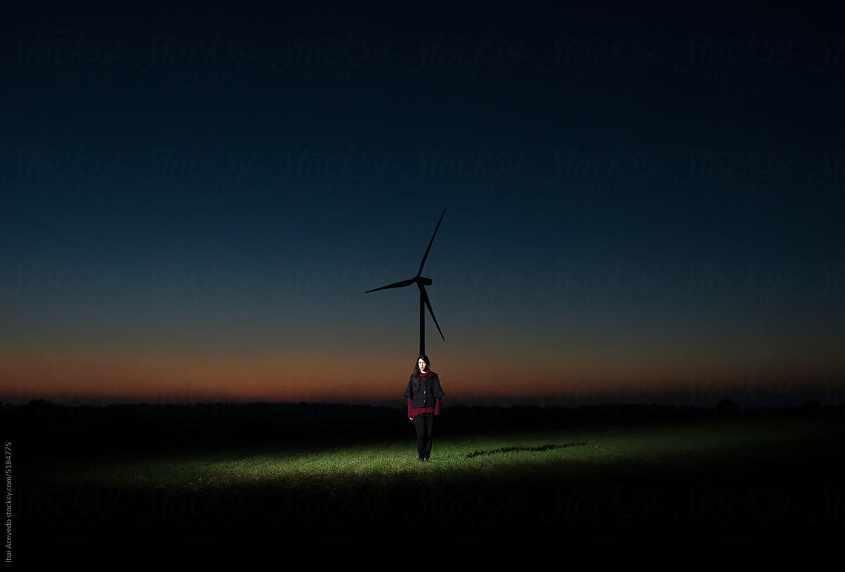 Surreal scenery with standing woman and windmill