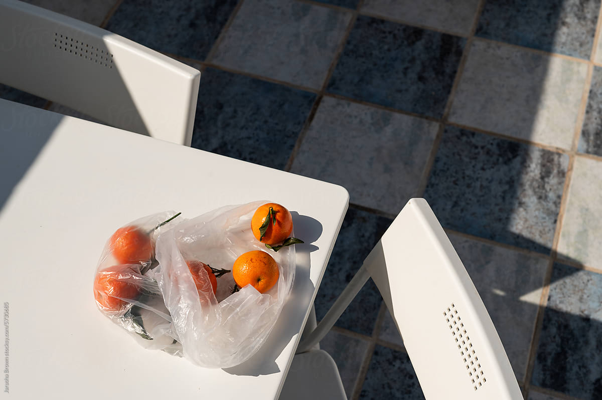 Tangerines on a patio table in the sun.