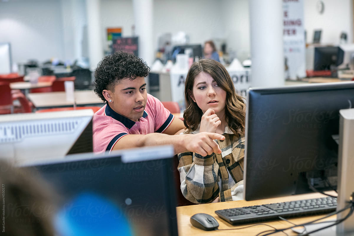 College Students Tutoring Other Students In Computer Lab