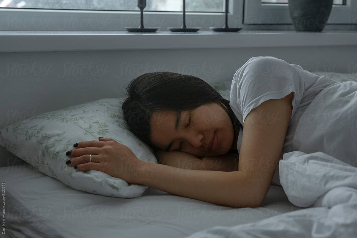 Female sleeping on bed in morning