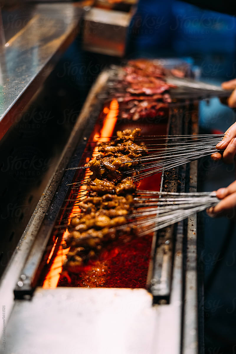 Street Food Vendor Grilling Skewered Meat