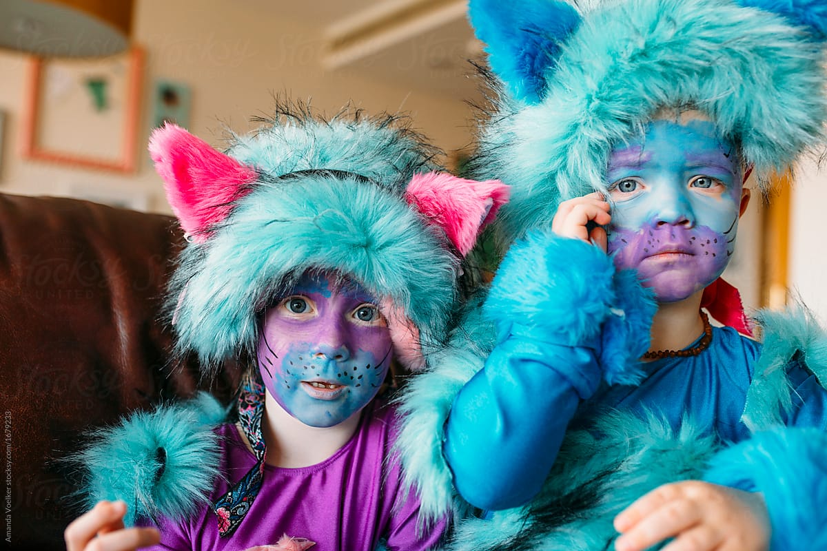 Portrait of Brother and Sister dressed up as colorful cats