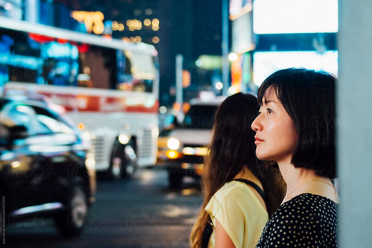 Asian woman waiting at the intersection in New York at night