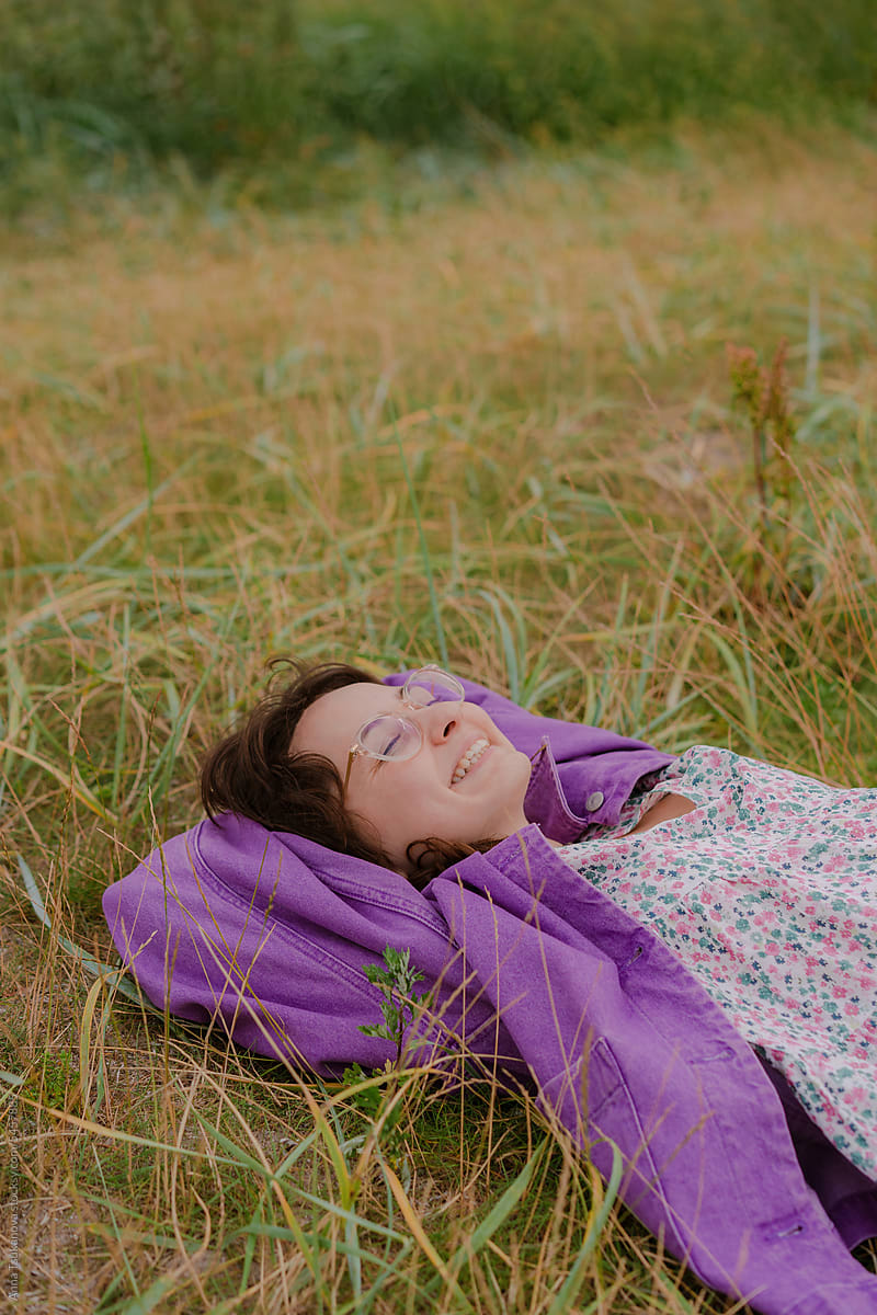 Woman in eyeglasses laying on grass