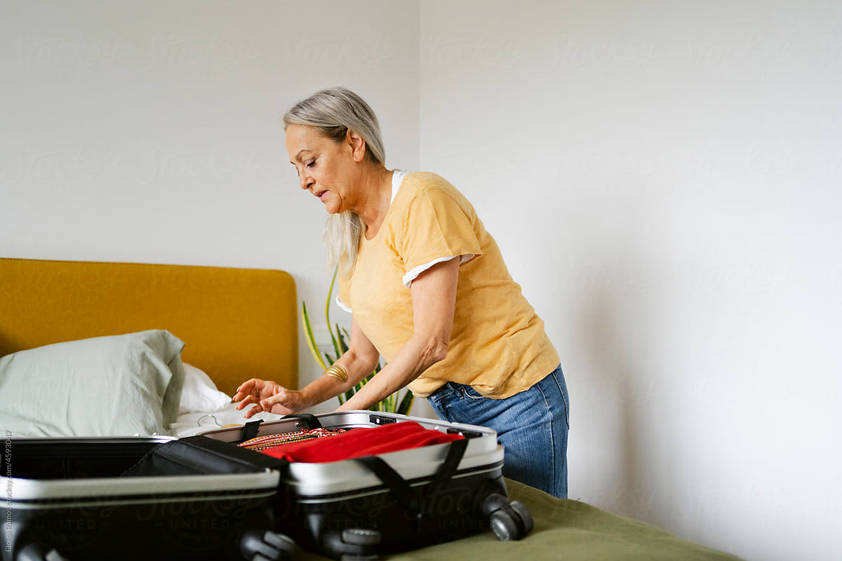 woman preparing suitcase at bedroom