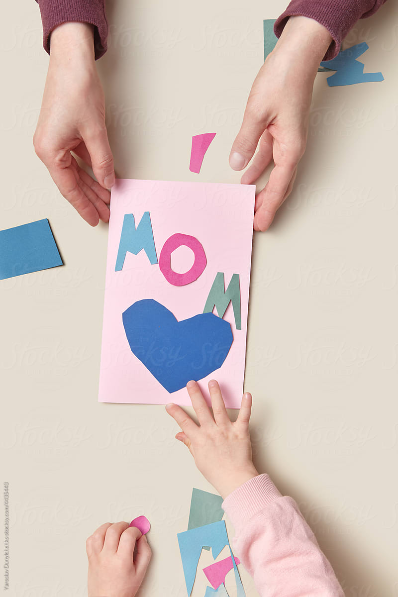 Mother holding paper greeting card from kid