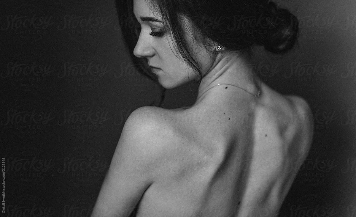 Nude girl posing at black background.
