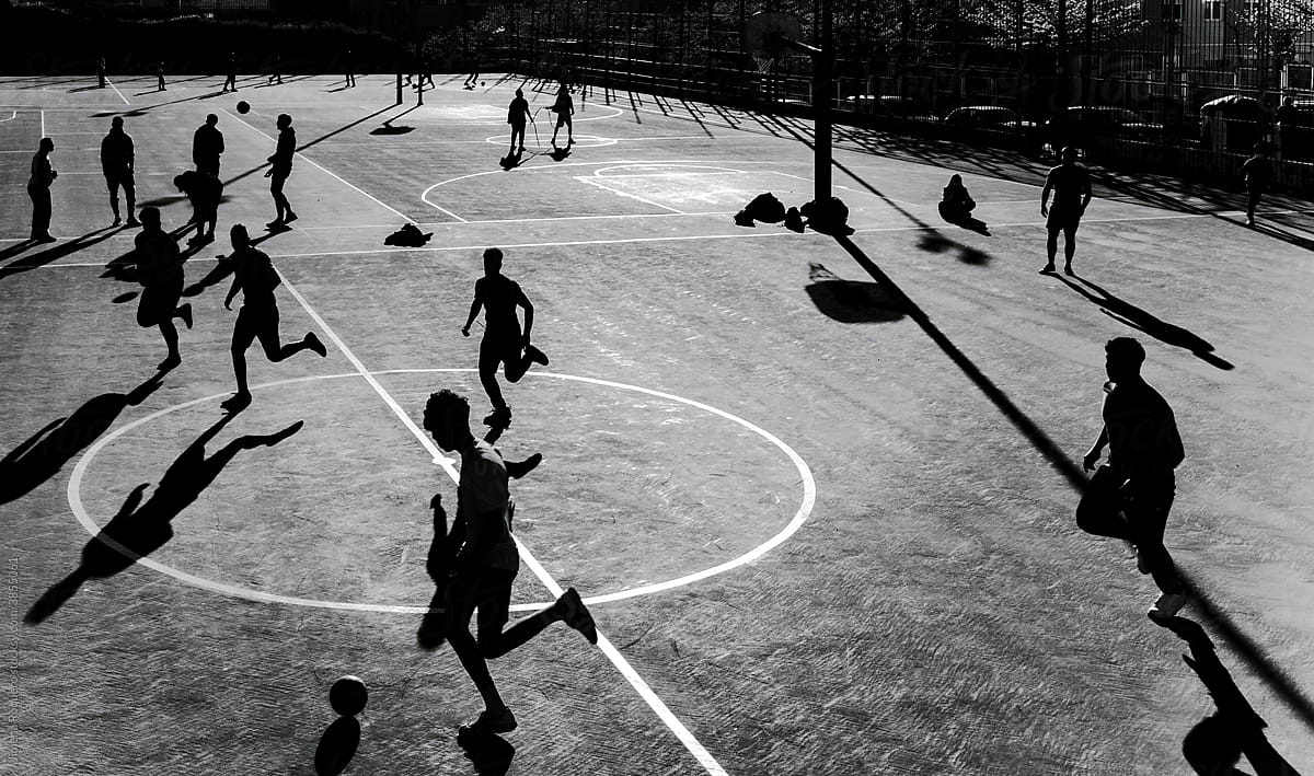 Group of people playing football in an outdoor court