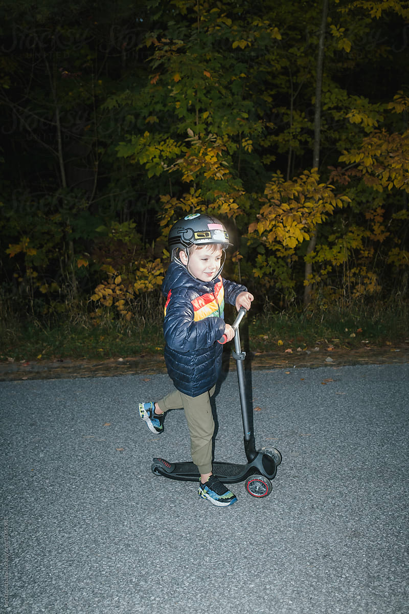 Boy riding scooter near the woods