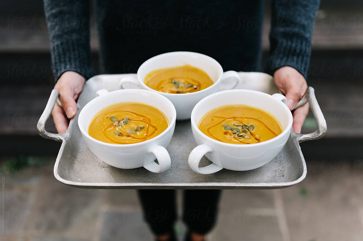 Woman holding a tray of soups
