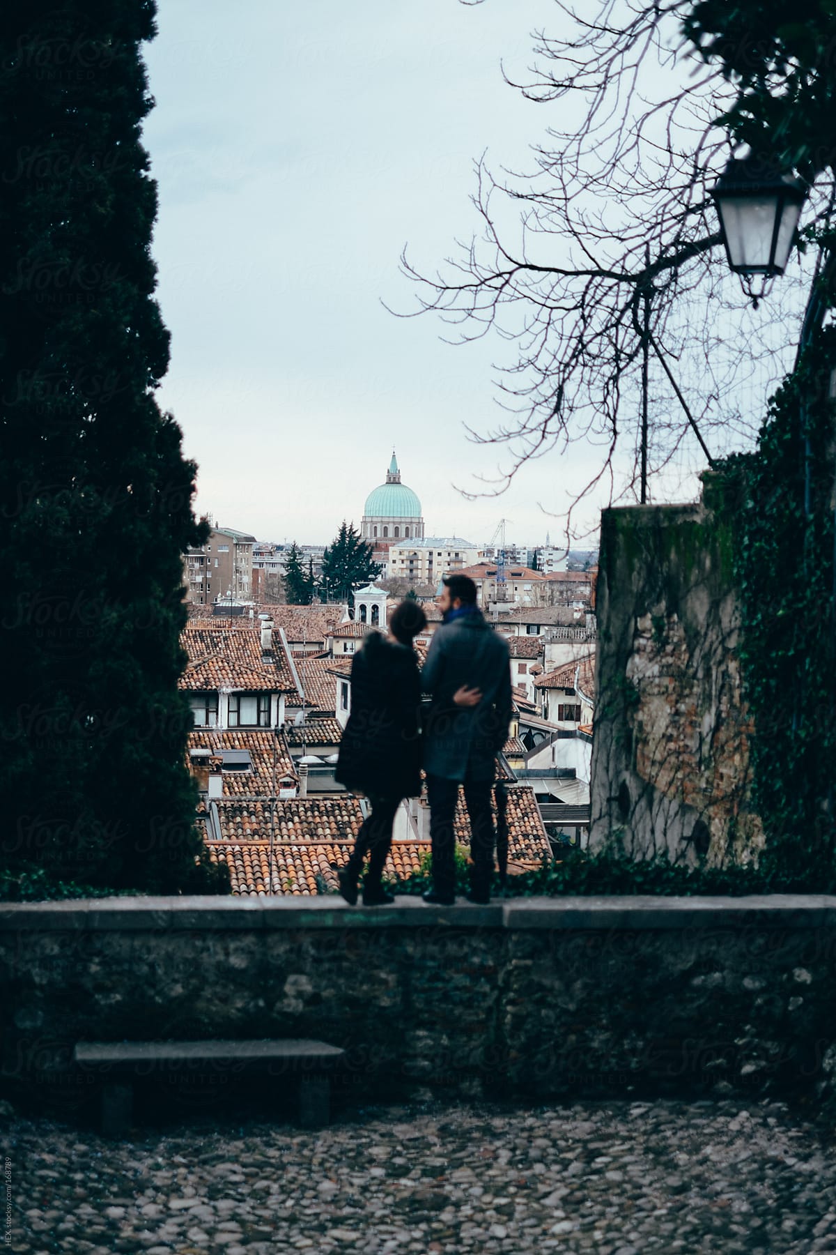 Back View of Young Couple Cuddling Visiting An Italian City