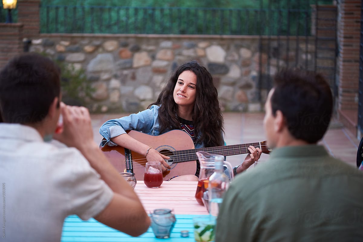 Brunette Playing Guitar At Outdoor Party By Stocksy Contributor
