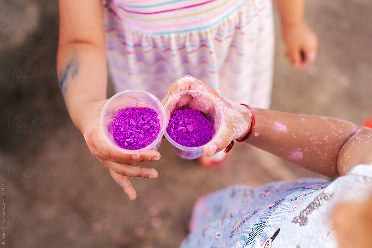 Crop children showing cups with purple color powders
