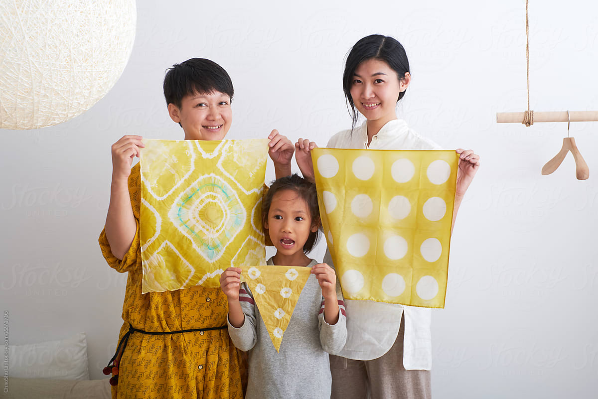 Beautiful Asian little girl and woman, holding plant dyed fabric.