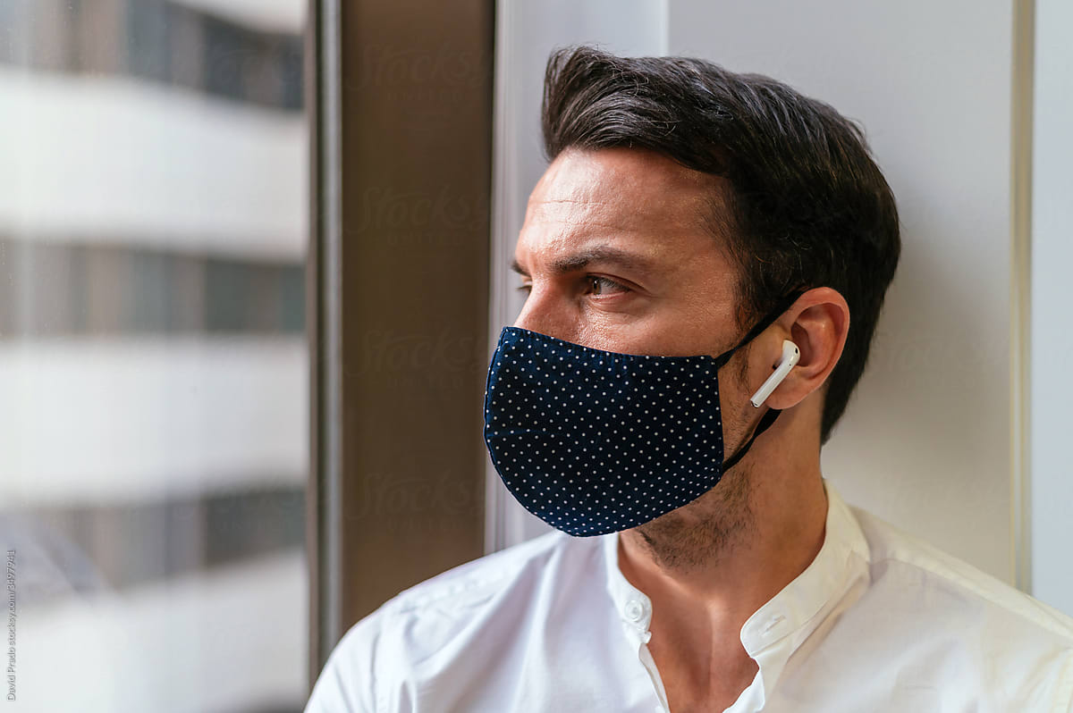Modern man in protective mask and earbuds