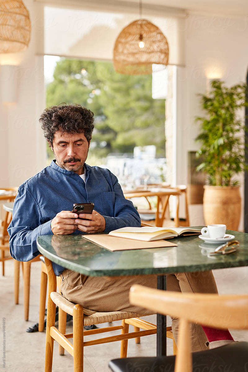 Businessman using smartphone during work in cafe