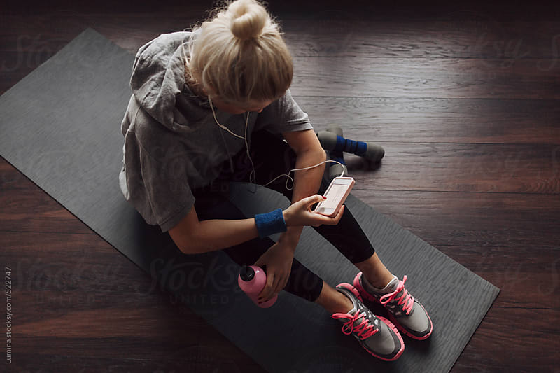 Woman Texting At The Gym By Lumina Stocksy United