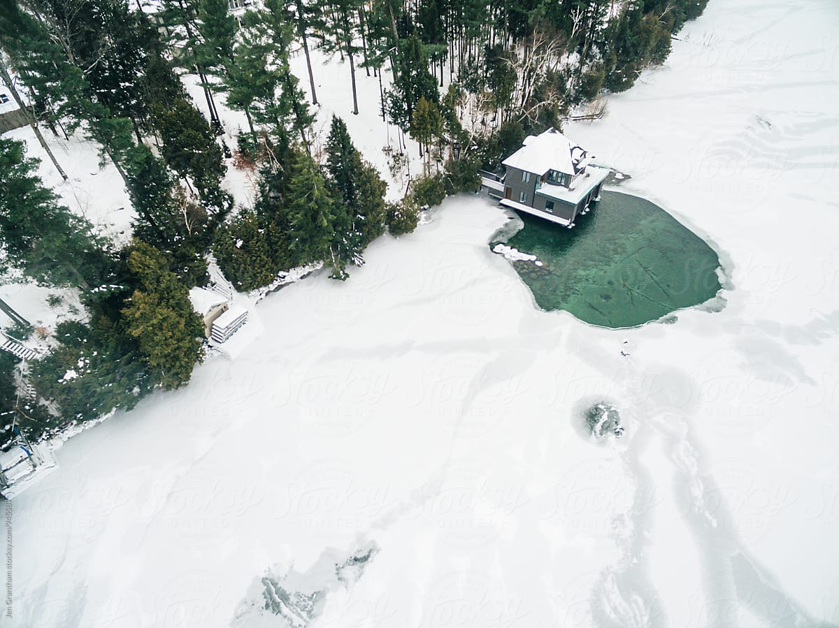 Aerial drone image of a boathouse on a frozen lake