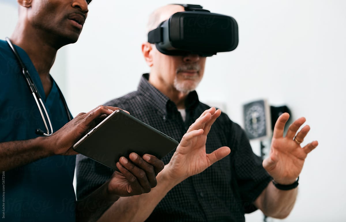 Exam: Senior Male Uses VR Headset While Doctor Uses Tablet Compu