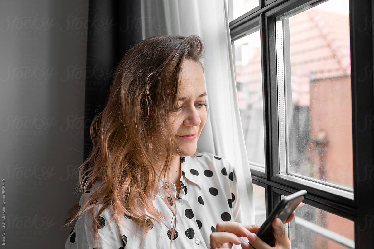 woman talk on the phone near the window