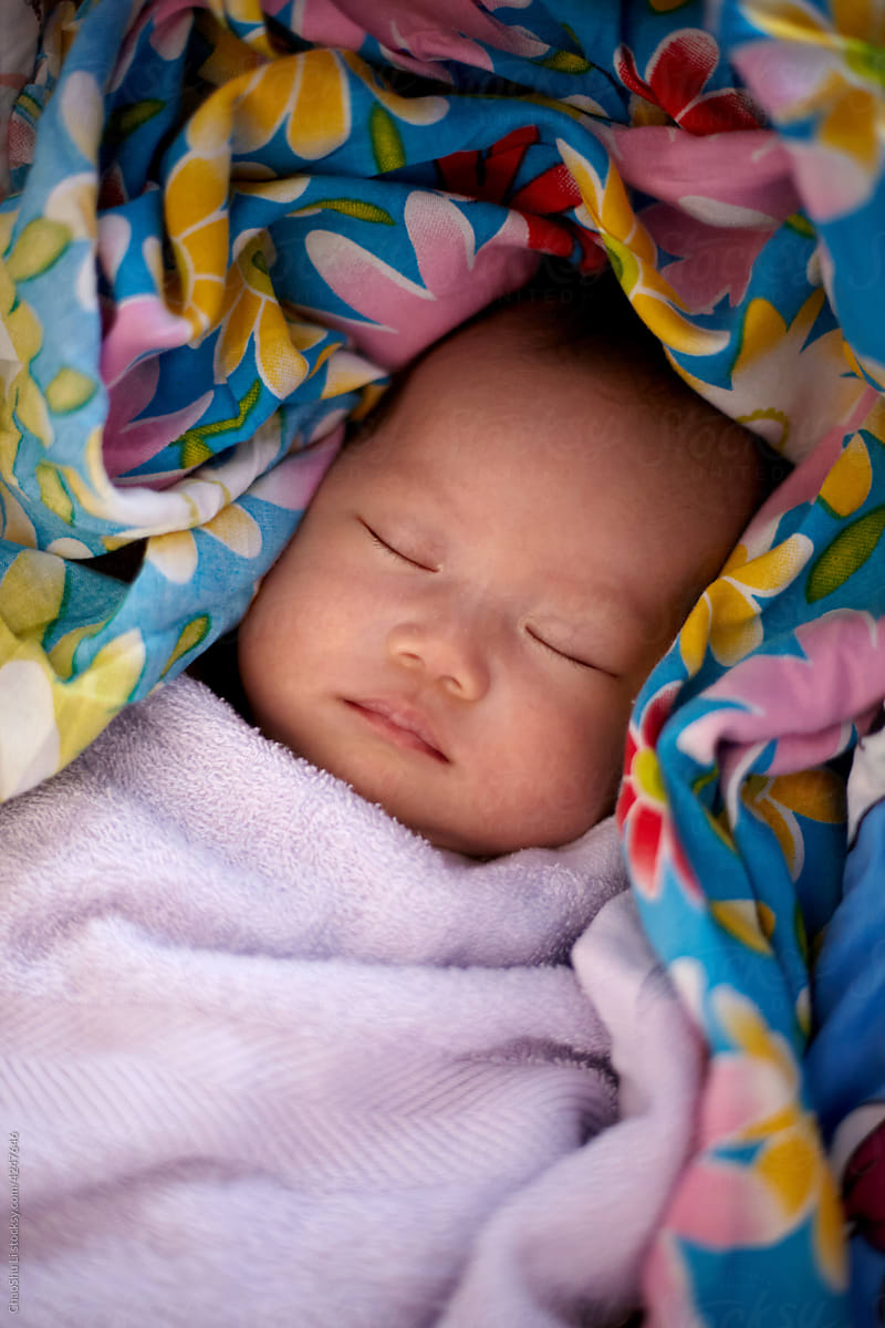 Newborn Asian baby in a warm bed