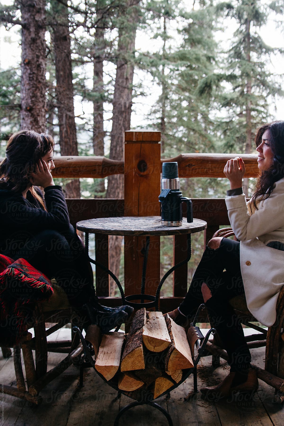two females talk during breakfast at cabin in woods