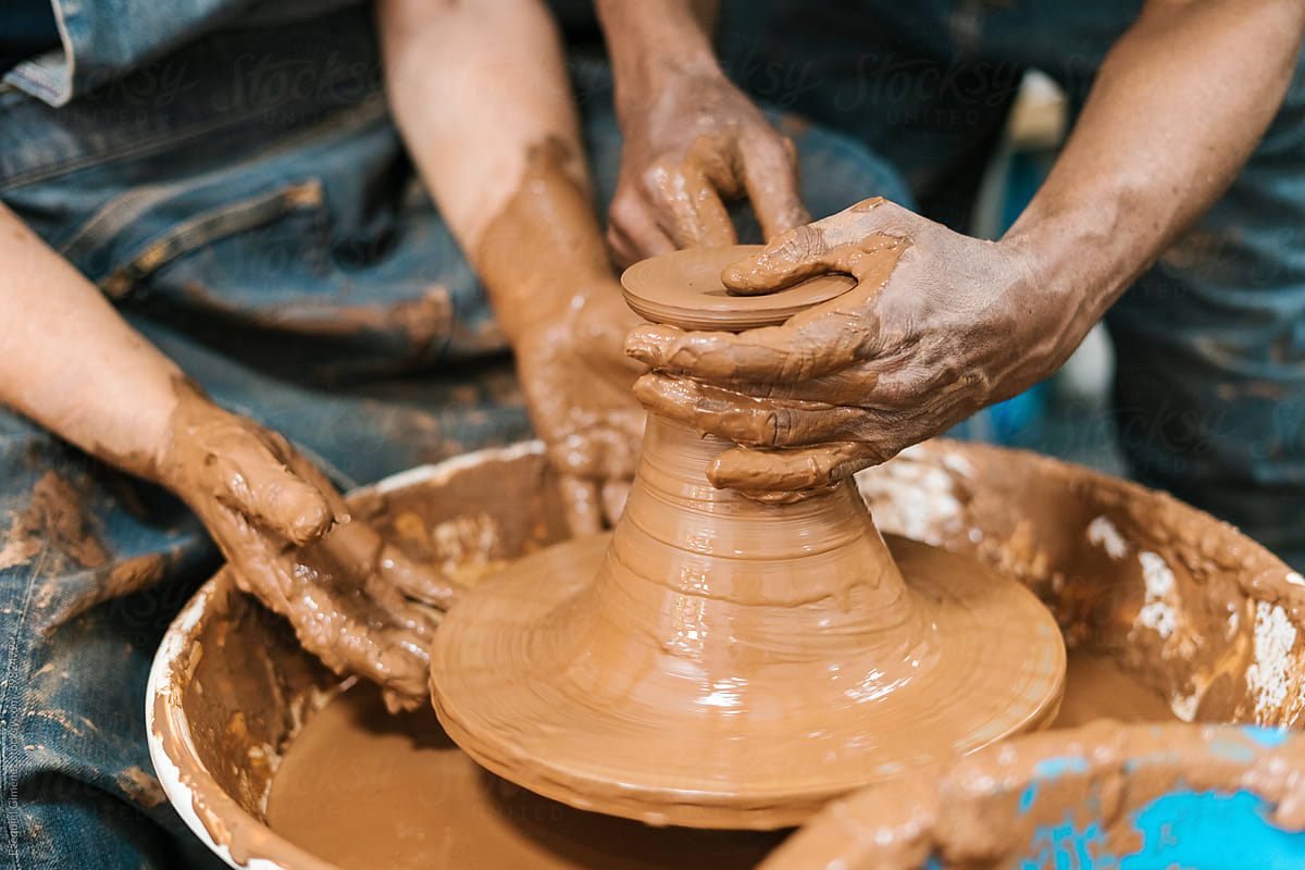 Crop artisans shaping vase on wheel
