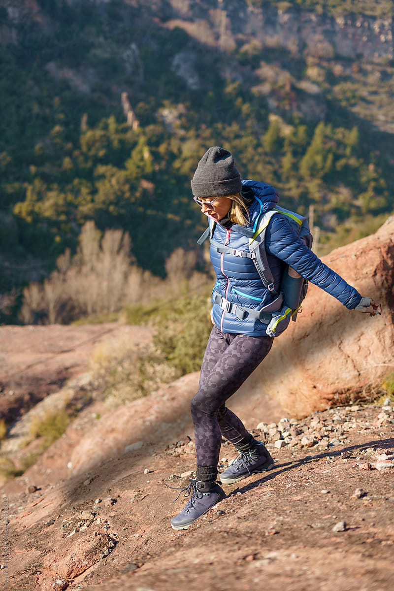 Active lady hiking in rough rocky terrain in highlands